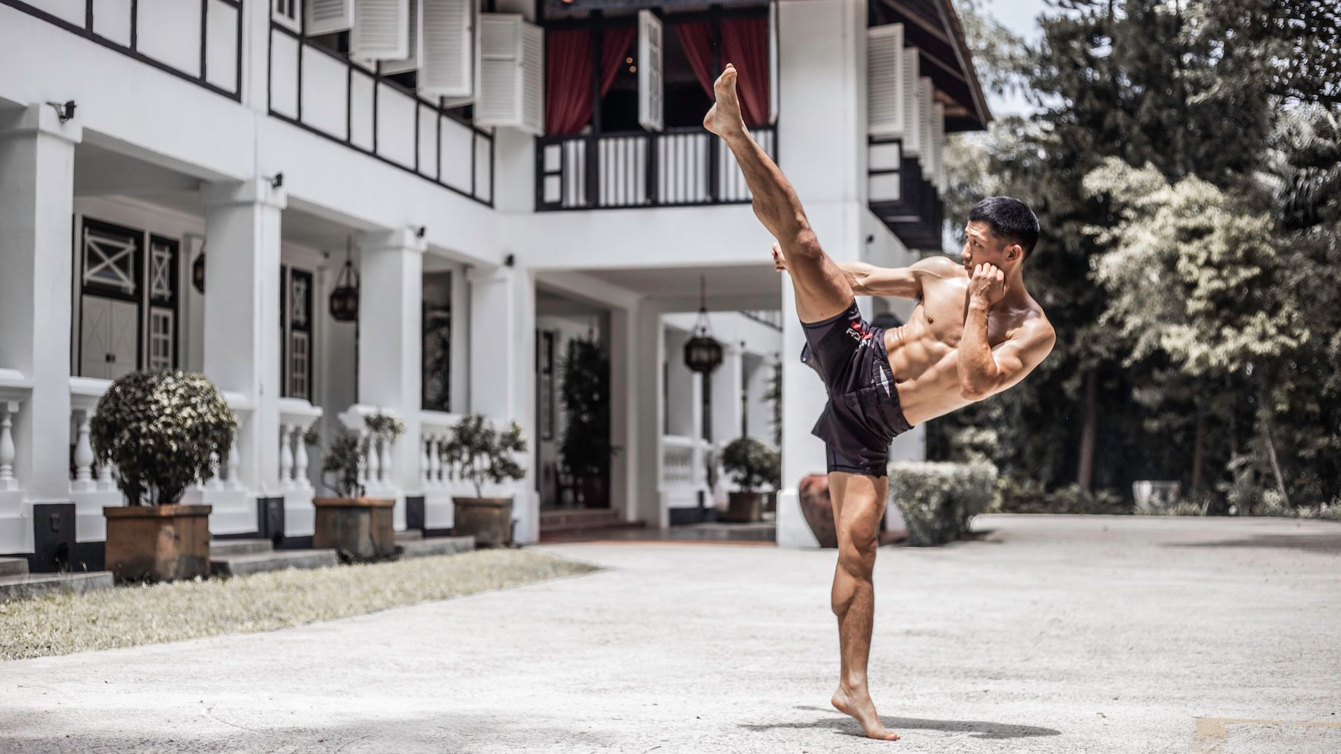 Hiroki akimoto kicking in front of a white house
