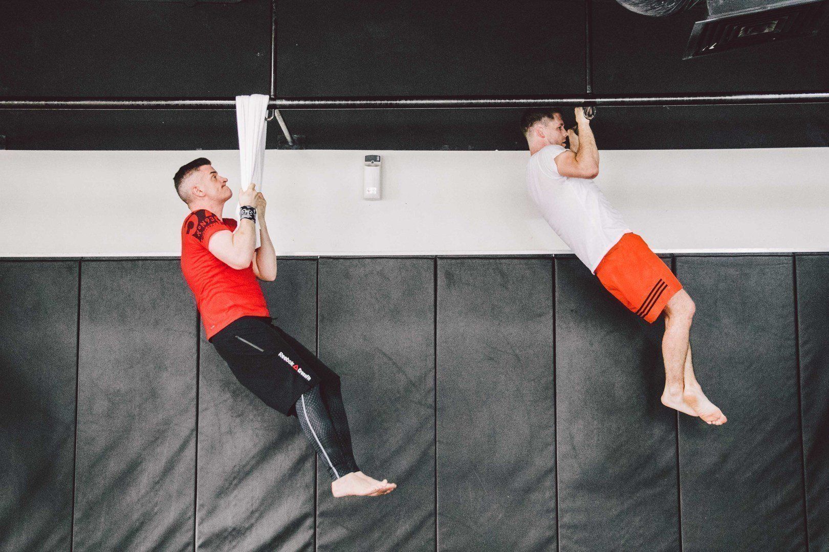two people doing pull-ups
