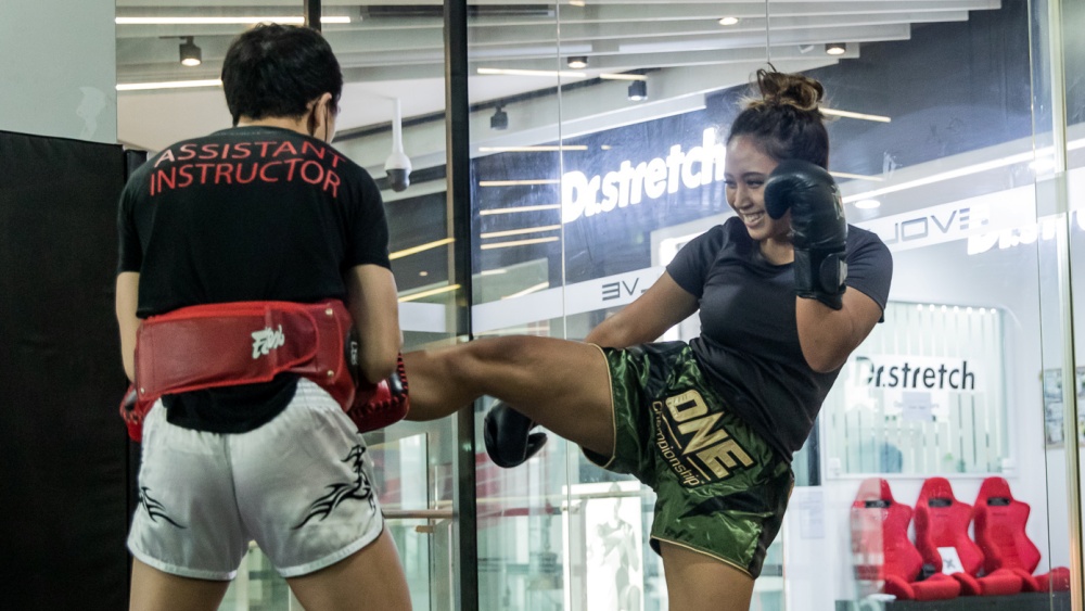 female student doing pad work